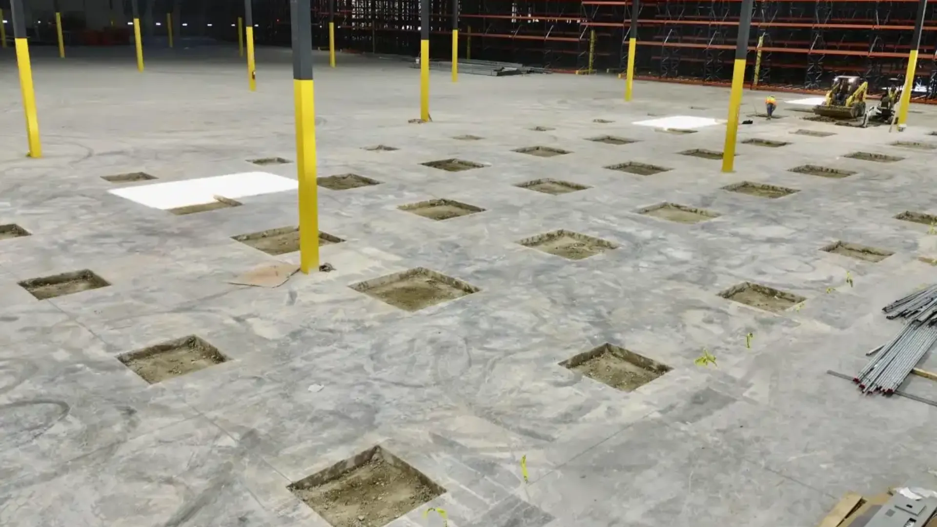 Aerial view of a construction site with workers pouring concrete.